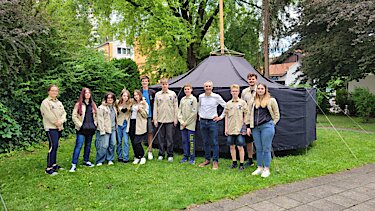 Erster Bürgermeister Norbert Seidl mit den Puchheimer Pfadfindern vor dem gemeinsam aufgebautem Zelt.